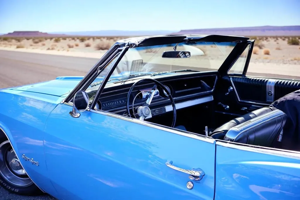 A blue convertible in a leafy car park, edited with FLUX 3 Image Klein: Put the convertible on an empty desert road under a clear sky